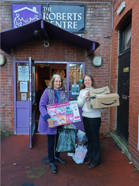 Donations Delivered to the Roberts Centre Two women at the Roberts Centre entrance holding donated gifts and bags