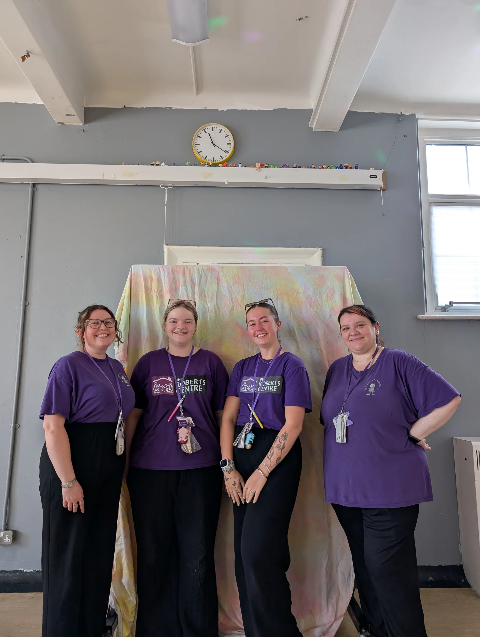 Roberts Day Nursery Team Four Roberts Day Nursery practitioners in purple tops standing together